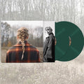 The Album cover artwork for Taylor Swift's Evermore LP, also displaying the two green vinyl records set against a forest background